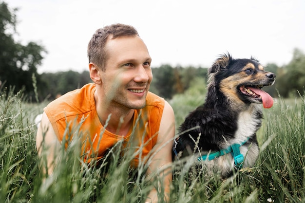 Portret van een jonge man met een hond op het veld