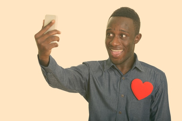 Portret van een jonge man met een smartphone op een grijze achtergrond