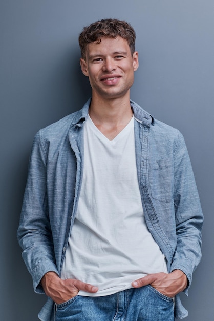 Portret van een jonge man op een grijze achtergrond