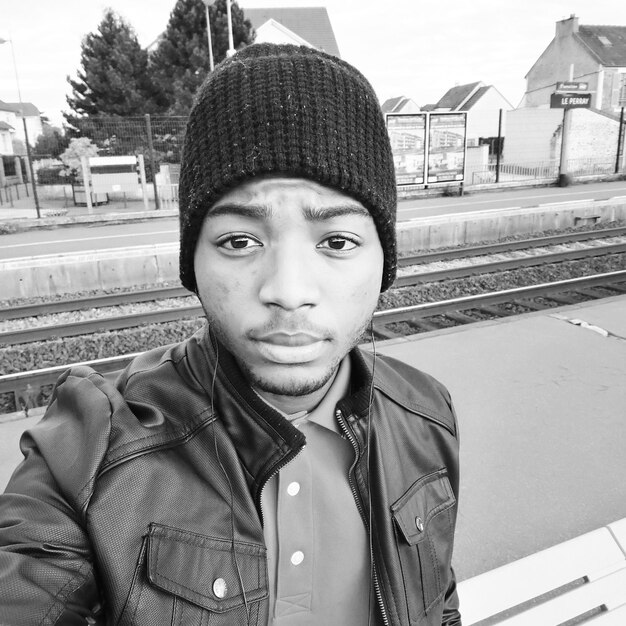 Portret van een jonge man op het perron van het treinstation