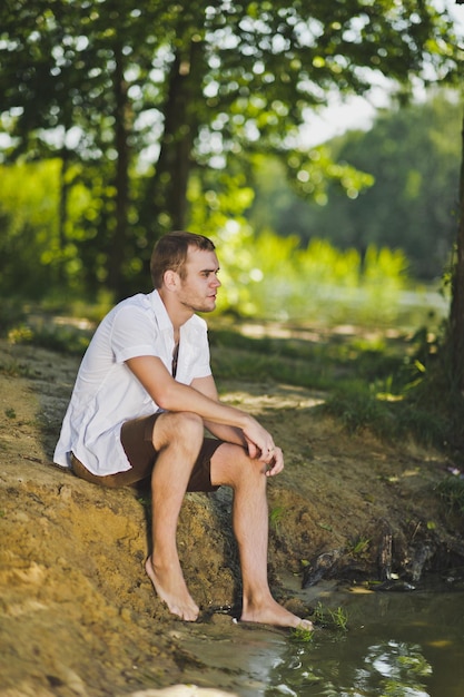 Portret van een jonge man zittend op het strand 6345