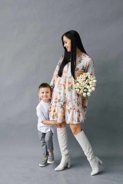 Portret van een jonge moeder met een boeket witte tulpen en een jonge zoon die plezier heeft Familie charmant