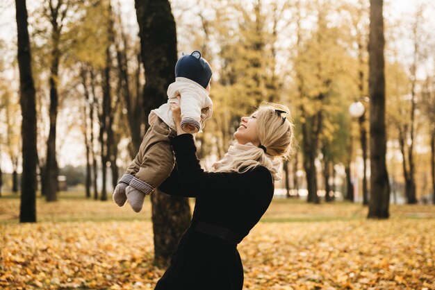 Portret van een jonge moeder met haar baby in de herfst Park.