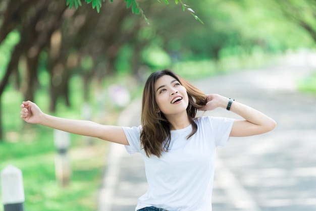 Portret van een jonge, mooie Aziatische vrouw die gelukkig is in het parkThailand-mensenLifestyle of modern girl