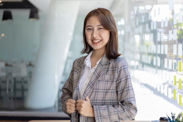 Portret van een jonge, mooie Aziatische vrouw in een kantoorruimte, conceptbeeld van Aziatische zakenvrouw, moderne vrouwelijke executive, startende zakenvrouw, bedrijfsleidervrouw.
