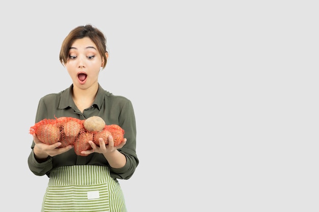 Portret van een jonge mooie boer vrouw met aardappelen in zak. Hoge kwaliteit foto