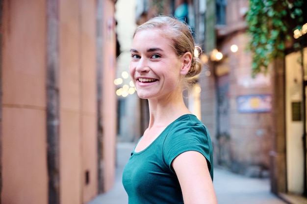 portret van een jonge mooie vrouw die buiten naar de camera kijkt met natuurlijk licht