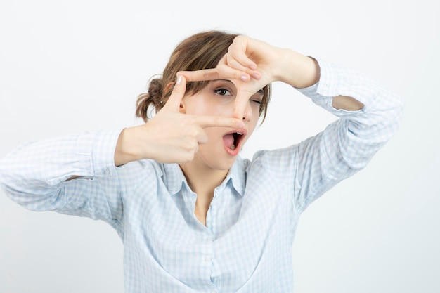 Portret van een jonge mooie vrouw die frame met vingers doet. Hoge kwaliteit foto