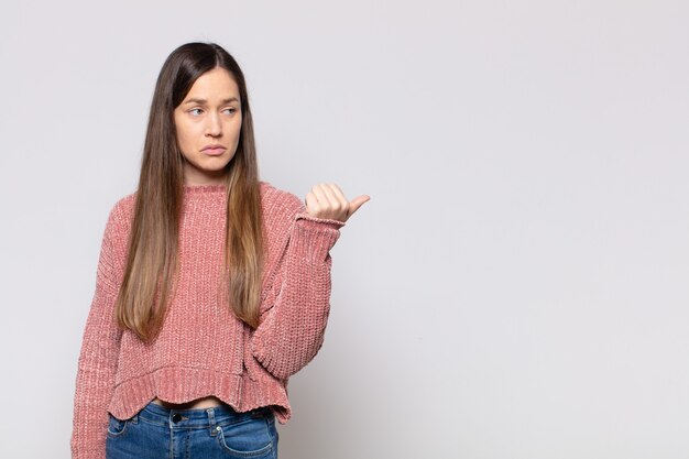 Portret van een jonge mooie vrouw die iets toont