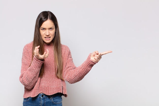 Portret van een jonge mooie vrouw die iets toont