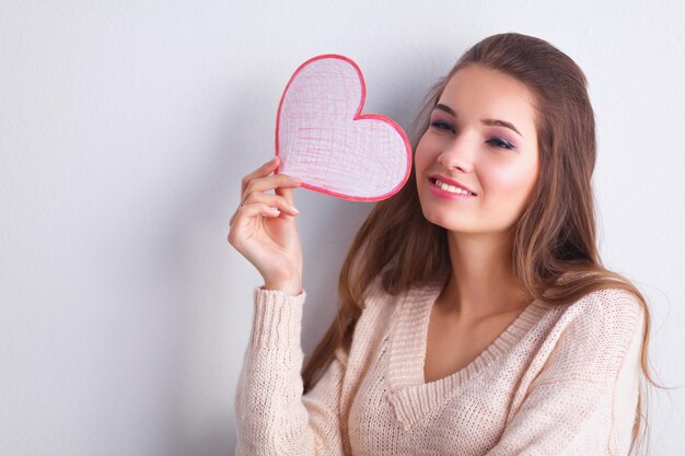 Portret van een jonge mooie vrouw die valentijnsdag cadeaukaart toont