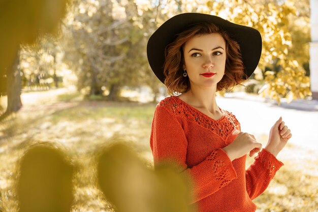 Portret van een jonge mooie vrouw in een hoed op een zonnige herfstdag.