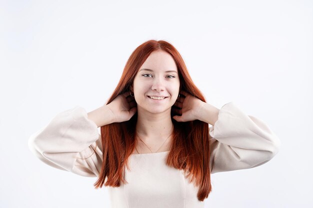 Portret van een jonge mooie vrouw wat betreft haar rode haar op witte achtergrondexemplaarruimte