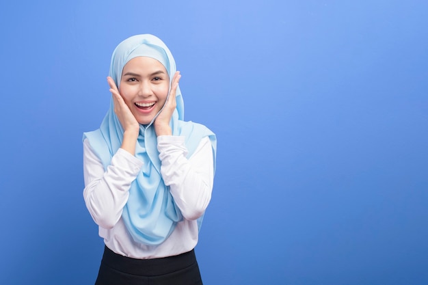 Portret van een jonge moslimvrouw met hijab over blauw