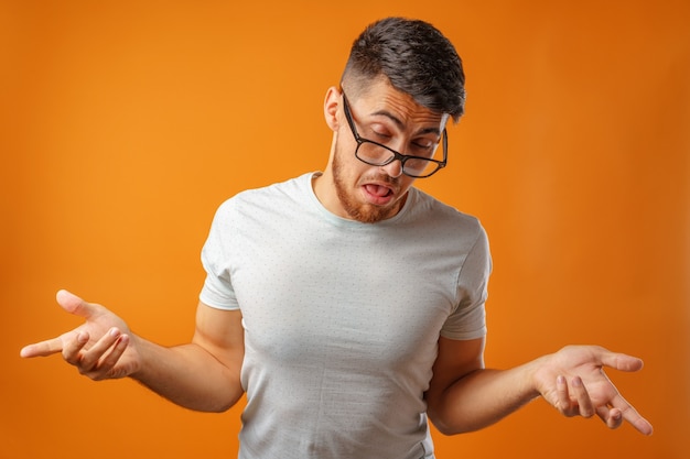 Portret van een jonge nerd man schouders ophalen