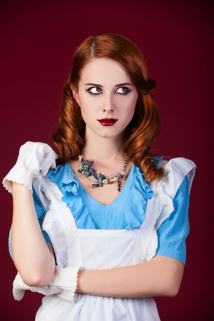Portret van een jonge roodharige vrouw verkleed als Alice in Wonderland, videogame.
