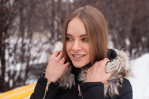 Portret van een jonge schattige vrouw in de winter die buiten staat