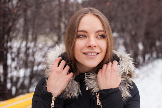 Portret van een jonge schattige vrouw in de winter die buiten staat