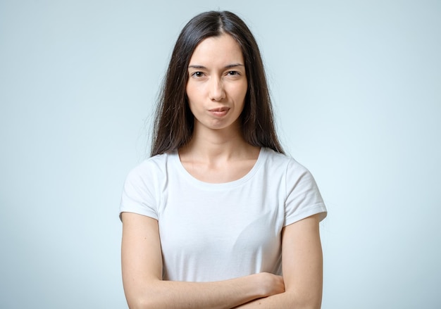 Portret van een jonge serieuze boze vrouw geïsoleerd op een witte achtergrond