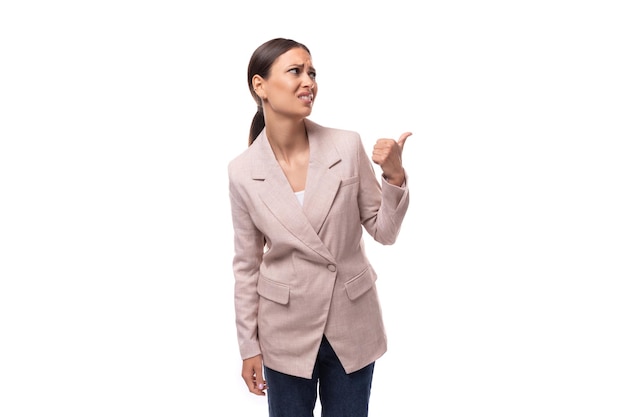 Portret van een jonge slanke brunette zakenvrouw met paardenstaart, gekleed in een jasje en spijkerbroek