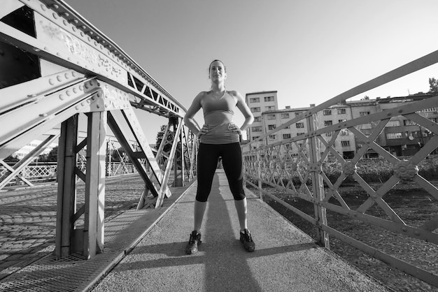 portret van een jonge sportieve joggende vrouw op zonnige ochtend in de stad