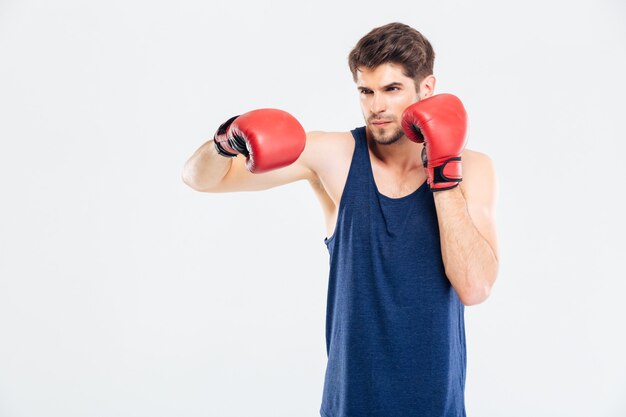 Portret van een jonge sportman boksen in rode handschoenen geïsoleerd op een grijze achtergrond