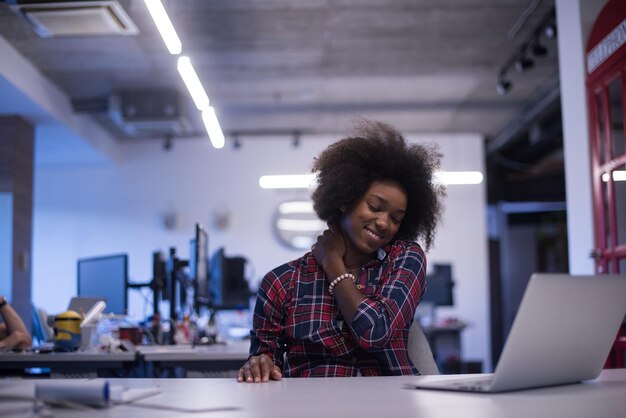 portret van een jonge, succesvolle Afro-Amerikaanse mooie vrouw die graag een goede en plezierige tijd doorbrengt terwijl ze in een groot, modern kantoor werkt