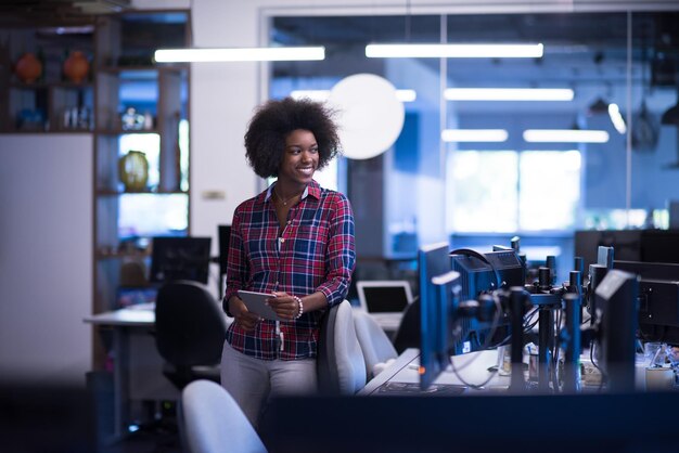 portret van een jonge, succesvolle Afro-Amerikaanse mooie vrouw die graag een goede en plezierige tijd doorbrengt terwijl ze in een groot, modern kantoor werkt