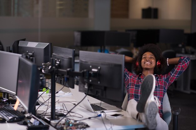 portret van een jonge, succesvolle Afro-Amerikaanse mooie vrouw die graag een goede en plezierige tijd doorbrengt terwijl ze in een groot, modern kantoor werkt