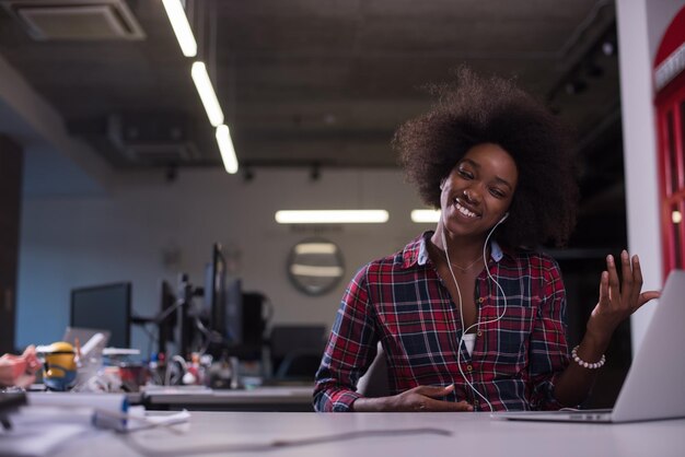 portret van een jonge, succesvolle Afro-Amerikaanse mooie vrouw die graag een goede en plezierige tijd doorbrengt terwijl ze in een groot, modern kantoor werkt