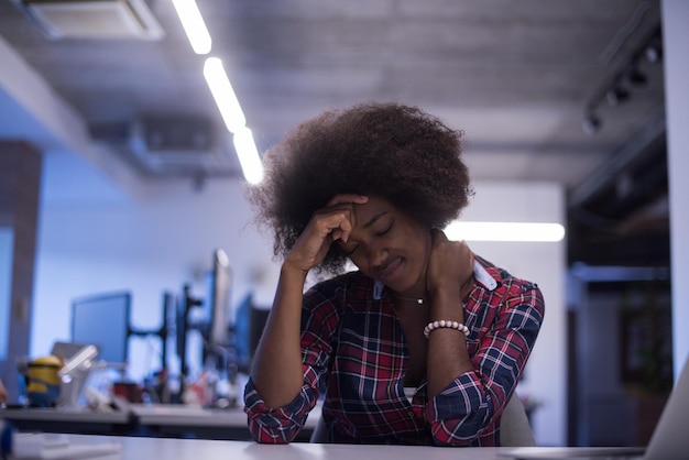 portret van een jonge, succesvolle Afro-Amerikaanse mooie vrouw die graag een goede en plezierige tijd doorbrengt terwijl ze in een groot, modern kantoor werkt