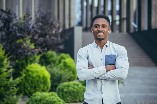 Portret van een jonge, vrolijke Afro-Amerikaanse man die naar de camera kijkt, glimlacht en zich verheugt