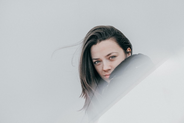 Portret van een jonge vrouw bij een grijze muur