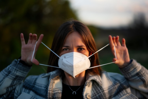 Portret van een jonge vrouw die beschermend masker buitenshuis zet