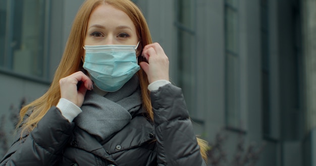 Portret van een jonge vrouw die beschermend masker op straat draagt.