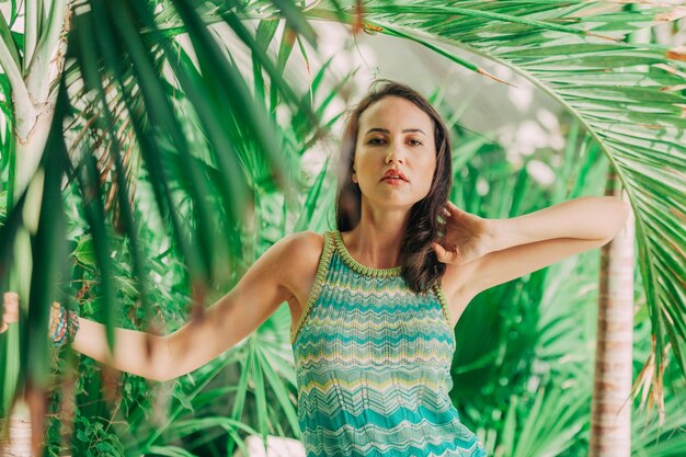 Foto portret van een jonge vrouw die bij bomen staat