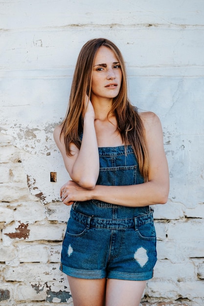 Portret van een jonge vrouw die bij de muur staat