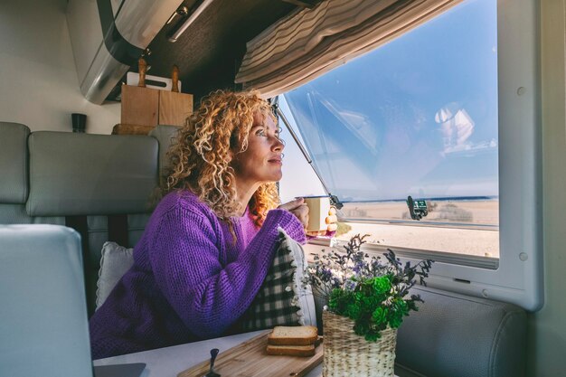 Foto portret van een jonge vrouw die door het raam kijkt