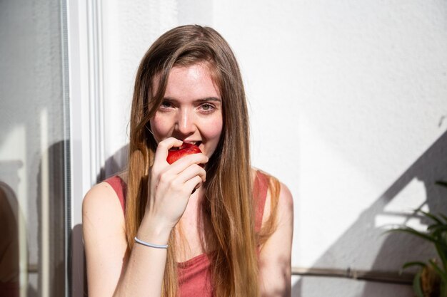 Portret van een jonge vrouw die een appel eet