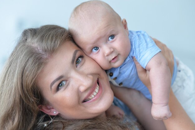 Portret van een jonge vrouw die een babyjongen vasthoudt