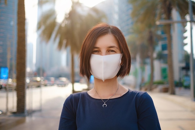 Portret van een jonge vrouw die een blauwe jurk en een wit masker draagt