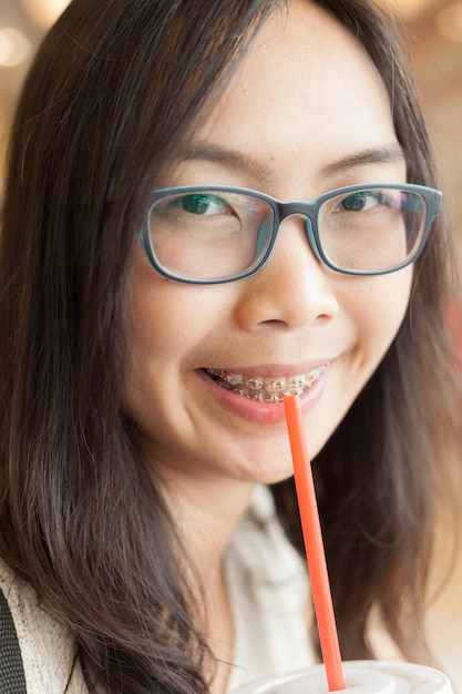 Portret van een jonge vrouw die een drankje drinkt