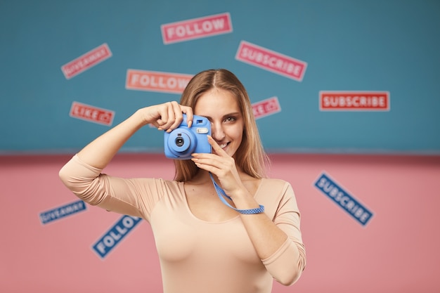 Portret van een jonge vrouw die een foto op fotocamera met verschillende borden maakt