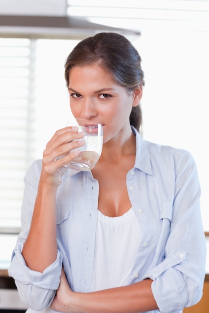 Portret van een jonge vrouw die een glas water drinkt