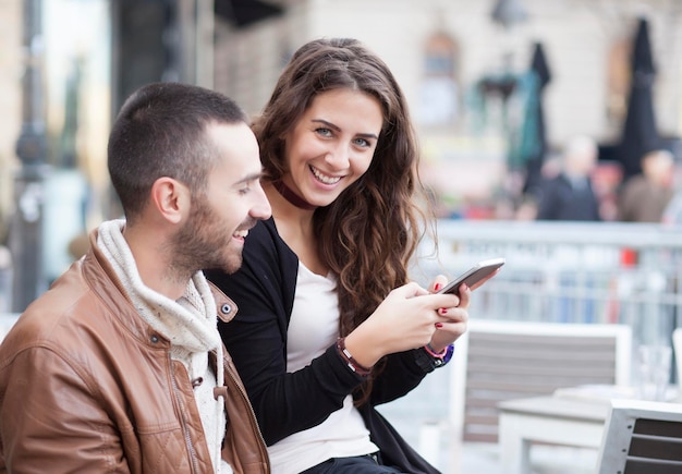 Foto portret van een jonge vrouw die een mobiele telefoon gebruikt in de stad