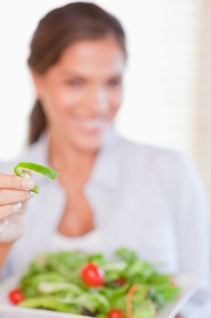 Portret van een jonge vrouw die een salade eet