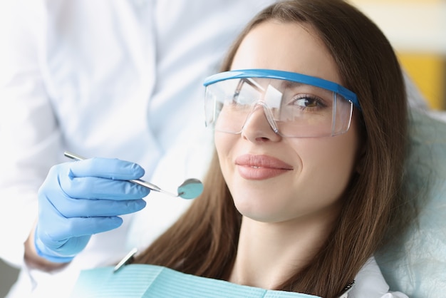 Portret van een jonge vrouw die een veiligheidsbril draagt als tandartsstoel
