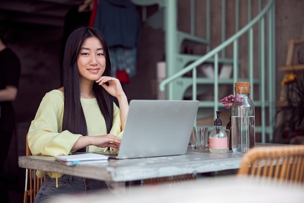 Portret van een jonge vrouw die gelukkig in de coffeeshop werkt