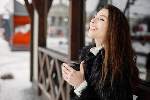 Portret van een jonge vrouw die in de winterstad staat en poseert voor een foto