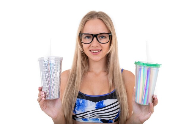 Portret van een jonge vrouw die in een blauw zwempak twee glazen limonade houdt